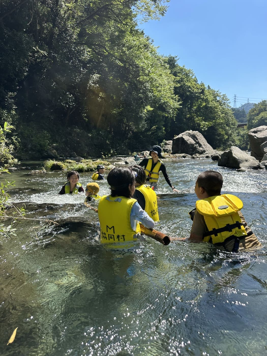 澄んだ川で水あそびを楽しむ子どもたち