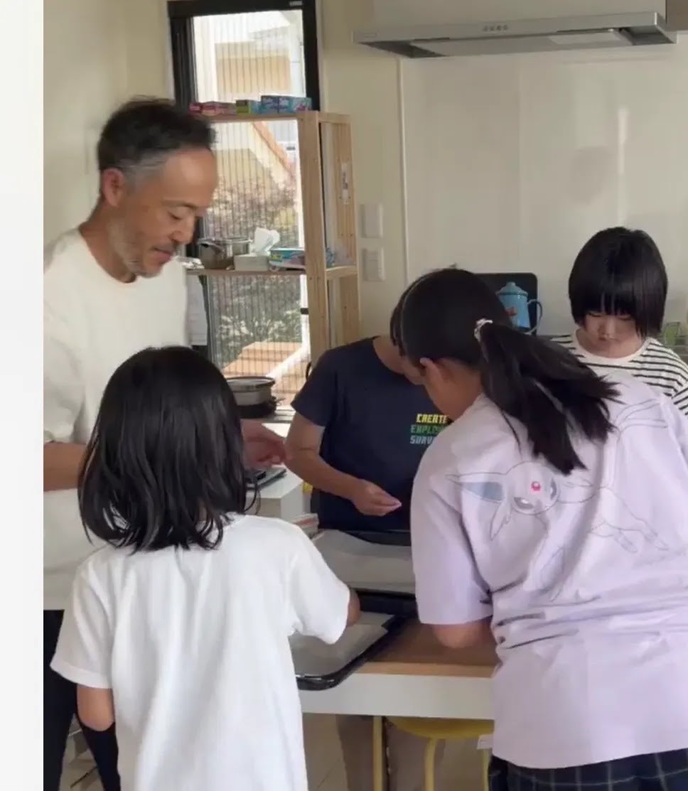 キッチンで並んで調理をする子どもたちとスタッフ